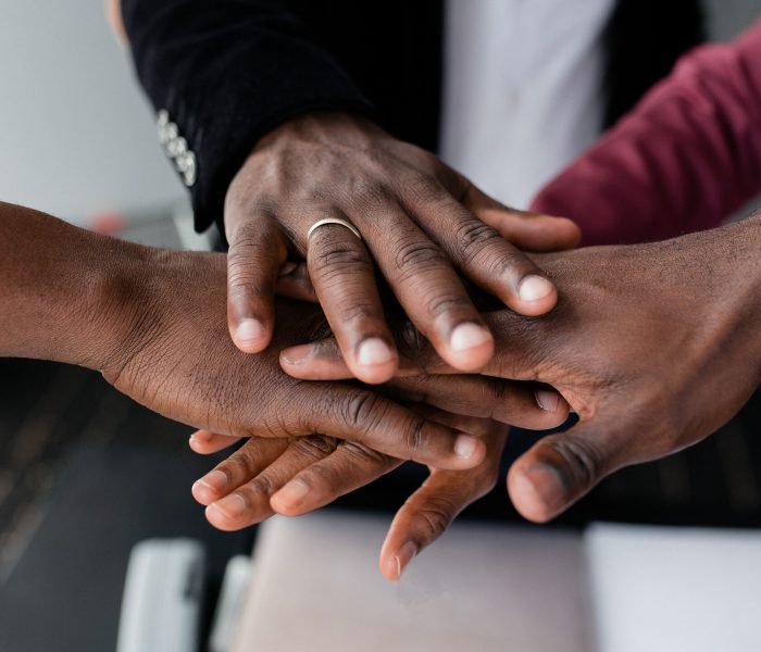 The hands of black people in the center hold each other to unite against racism in large countries. Black lives matter